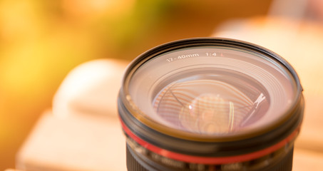 Profi-Objektiv auf Tisch, draußen, warme Farben, Breitbild