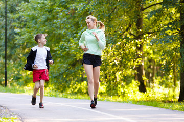 Young family jogging in the open air Happy mom with 9 years old child running at summer park