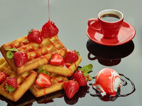 Viennese waffles with strawberries and ice cream and a cup of coffee on the reflective background