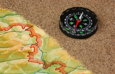 Obraz na płótnie Canvas compass on the map with sand