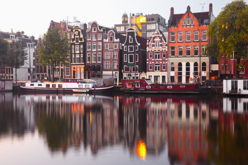Amsterdam canal Amstel with typical dutch houses and houseboat from the boat in the morning, Holland, Netherlands.