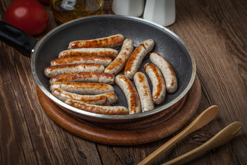 Fried white sausages in a cast iron skillet.