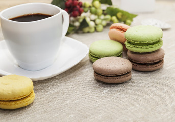 French cookies on a wooden table and coffee in a white mug, macaroons