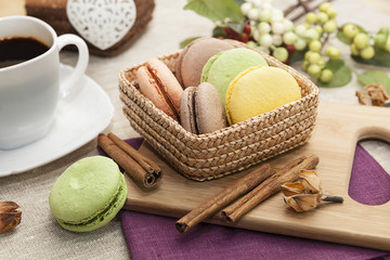 French cookies on a wooden table and coffee in a white mug, macaroons