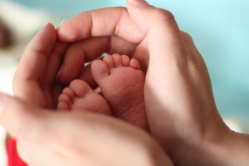 Obraz na płótnie Canvas baby's legs and father's hands