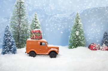 verschneite winterlandschaft mit auto und weihnachtsgeschenk und Tannenbäumen