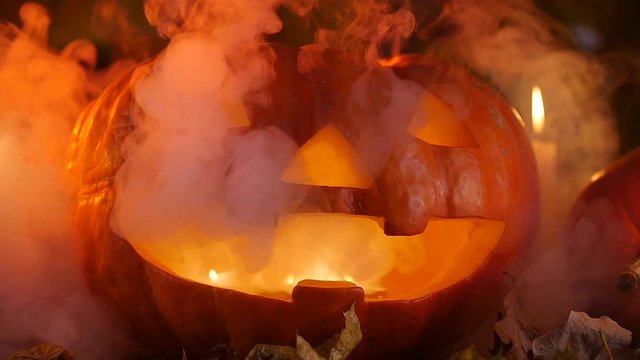 Creepy halloween pumpkins and candles in the smoke