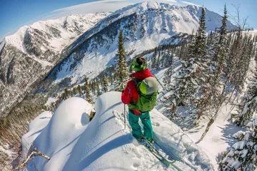 Fotobehang Man standing at top of ridge. Ski touring in mountains. Adventure winter freeride extreme sport © Baikal360