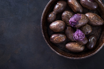 Raw potato food . Fresh blue potatoes on dark background. Free place for text.