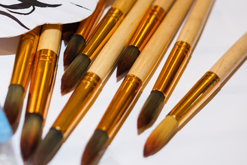 Set of brushes for painting pencils spatula in the bank against the backdrop