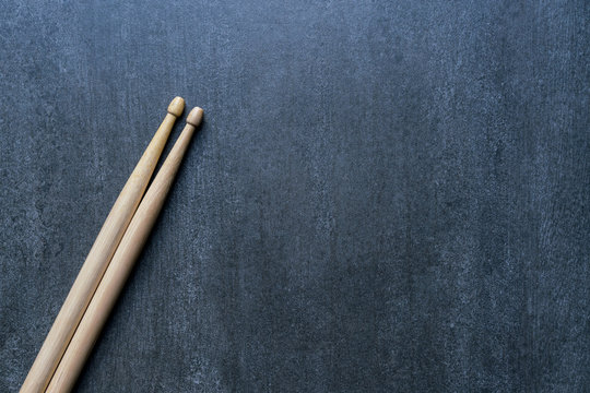 Drum stick on black table background, top view, music concept