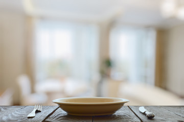 empty plate with fork and knife on wooden table