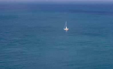 Obraz premium Lonely sailing yacht in the sea