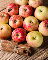 Group of ripe apples with cinnamon over wooden texture