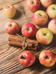 Group of ripe apples with cinnamon over wooden texture