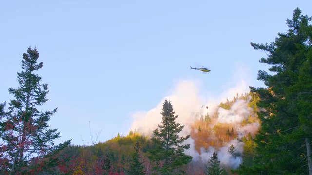 A helicopter dumps water on a forest fire in the White Mountains of New Hampshire