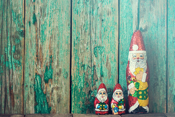 Chocolate Santa Claus with christmas lights on a old wooden background. christmas concept
