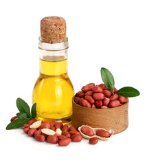 peanut oil in a glass bottle with peanuts in bowl
