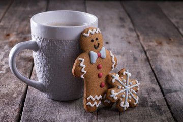 Cup of hot chocolate or cocoa with gingerbread cookie christmas composition on vintage wooden table background.