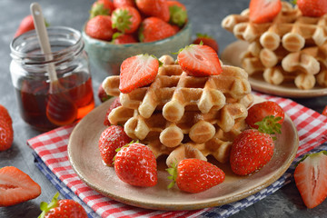 Traditional waffles with maple syrup and strawberries