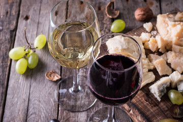 Different kinds of cheeses, wine, fruits and snacks on rustic wooden table . still life concept