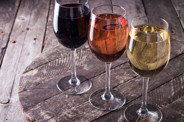 Different kinds of cheeses, wine, fruits and snacks on rustic wooden table . still life concept