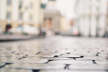 low angle shot of wet old pavement in Tallinn with shallow focus