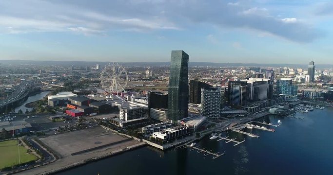Melbourne city CBD from Docklands area over Yarra river towards waterfront in aerial rotation panorama.
