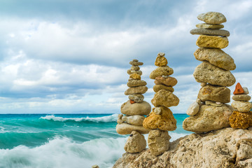 Fototapeta na wymiar A balanced pile of stones in front of the waves