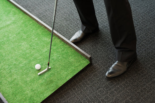 Close Up. A Man In A Business Suit Plays Golf In The Office