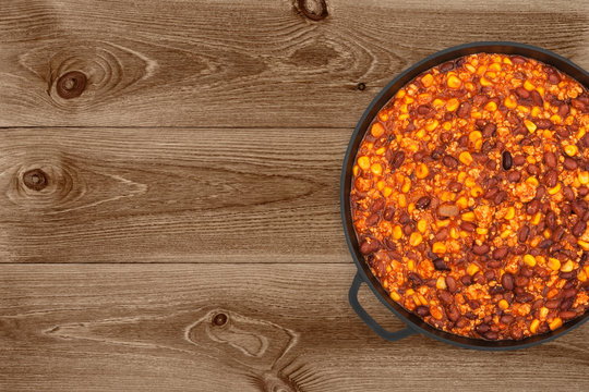 Hot Chili Con Carne In A Cast Iron Pan On Dark Wooden Background, Top View
