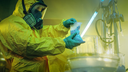 In the Underground Laboratory Clandestine Chemists in Protective Coveralls Package For Distribution Newly Cooked Batch of Drugs. They Illicitly Cook Drugs with Special Lab Equipment.