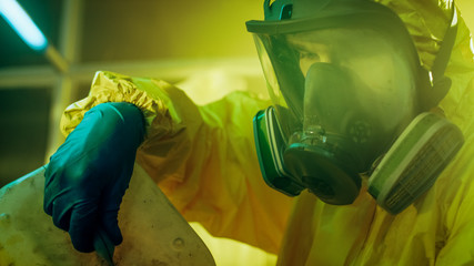 In the Underground Drug Laboratory Clandestine Chemist Wearing Protective Mask and Coverall Mixes...