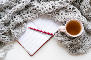 Open notebook and morning cup of tea on rustic wooden table top view. Cozy autumn breakfast. Fall bucket list. Flat lay style.