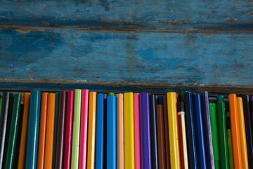 Various color pencils arranged on wooden table