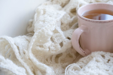 Warm and comfy autumn or winter concept. Book, cup of lemon tea and sweater on wooden window sill in old house. Reading and relaxing in cold fall weather at home. Quiet silent homely scene.