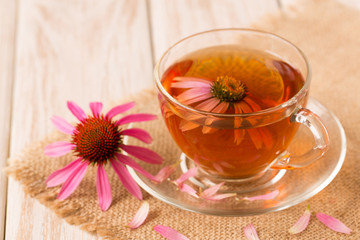 Cup of echinacea tea on white wooden table