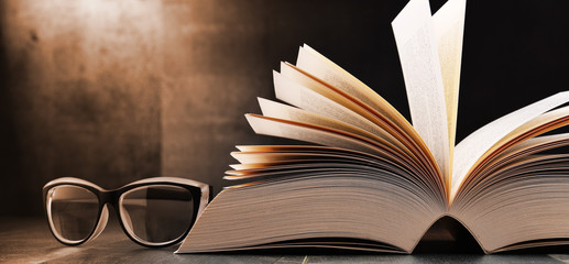 Composition with open book and glasses on the table