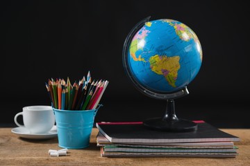 Various school supplies and globe on table