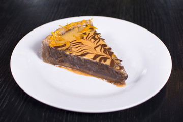 Delicious chocolate cake on plate on table on a dark background. Beautiful restaurant dessert.