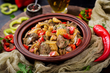 Roast chicken liver with vegetables on wooden background.