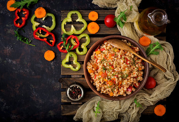 Vegetarian crumbly pearl barley porridge with vegetables  in a dark background. Flat lay. Top view