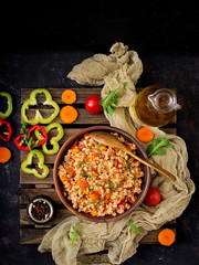 Vegetarian crumbly pearl barley porridge with vegetables  in a dark background. Flat lay. Top view