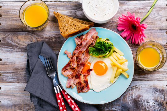 Continental breakfast with fried eggs, bacon and drinks. Ketogenic diet concept. Space for text