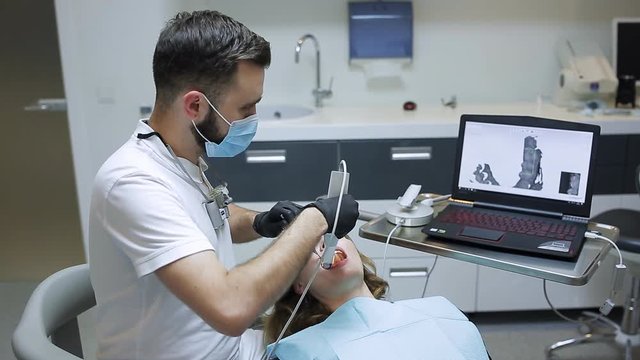 The dentist scans the patient's teeth with a 3d scanner.