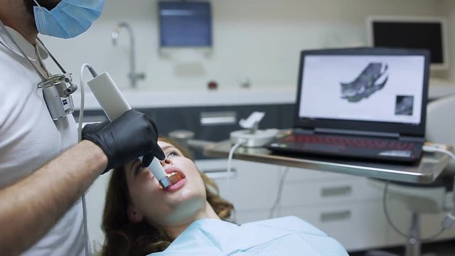 The dentist scans the patient's teeth with a 3d scanner.