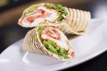 Burrito with grilled chicken and vegetables. Shawarma from juicy beef, lettuce, tomatoes, cucumbers, paprika and onion in pita bread.