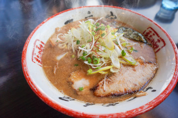 Japanese ramen soup with pork on dark wooden background