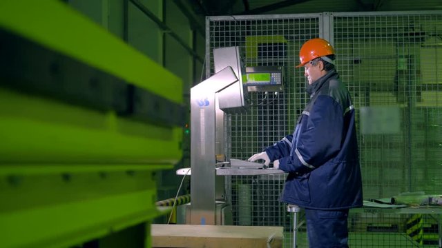 Worker with control board in a warehouse. Operator working with control board. 4K.