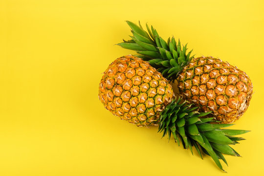 Pineapple on yellow background with copy space